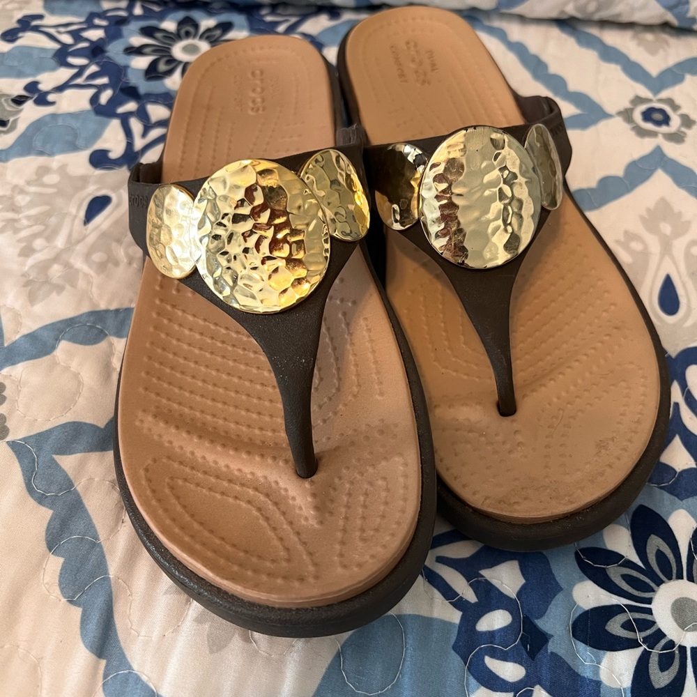 Size 6 Brown Crocs with Gold design. One extra left shoe. Reason in description
